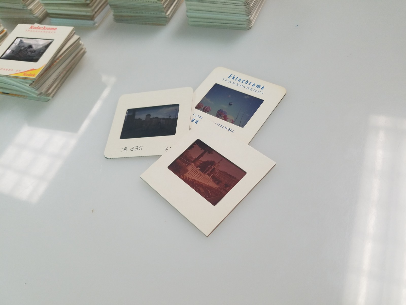 Three photography slides on a white table.